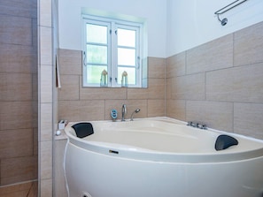 A modern bathroom with a freestanding bathtub, a window with a view, and tiled walls. - 4 Star Holiday Home in Glesborg (Glesborg)