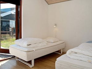 A bedroom with a bed, a bedside table, and a window. - 8 Person Holiday Home in Ulfborg (Ulfborg)