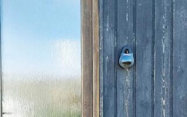 A weathered wooden door with a metal handle.