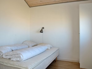 A single bed with a headboard, a bedside lamp, and a wooden floor. - 8 Person Holiday Home in Ulfborg (Ulfborg)