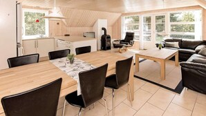 A modern, open-plan living space with a kitchen, dining area, and seating area.