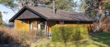 A rustic cabin with a sloped roof, a chimney, and a wooden exterior.