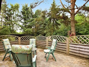 An outdoor seating area with a wooden fence, chairs, and a table. - Rustic Holiday Home in Asnæs near Sea (Asnaes)