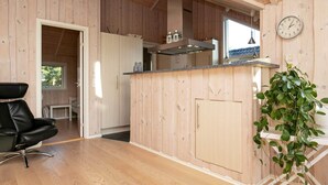 Een moderne keuken met houten keukenkasten, een inbouw eiland en een klok aan de muur.
