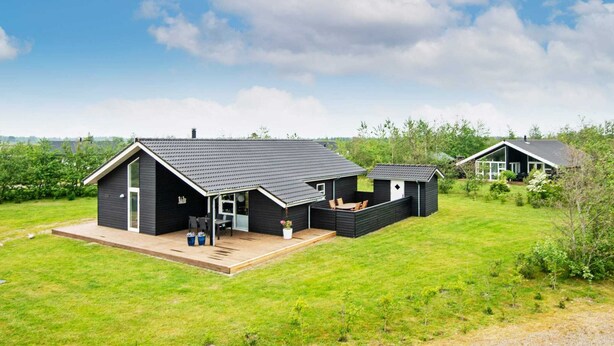 A modern, two-story house with a large deck and a covered outdoor seating area. - 8 Person Holiday Home in Brovst (Brovst)