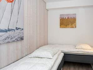 Una habitación con una cama, un cuadro colgado en la pared y un panel de madera.