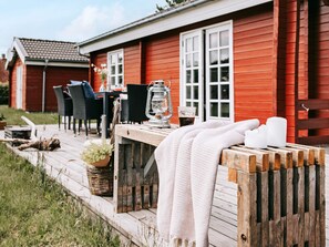 A wooden deck with outdoor furniture, a lantern, and a towel. - 4 Star Holiday Home in Vinderup (Vinderup)