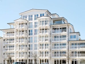 Un edificio de varios pisos con balcones y ventanas grandes.