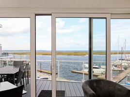 Eine Terrasse mit Blick auf einen Hafen und offenes Wasser.