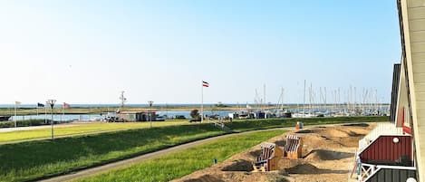 A coastal marina with boats, a flag, and a building with a red roof.