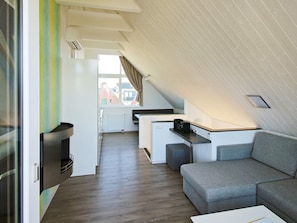 A compact living space with a kitchenette, a sofa, and a dining area. - Holiday Home in Wendtorf (Wendtorf)