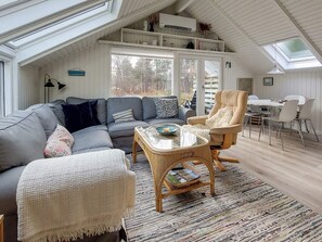 A cozy living room with a sectional sofa, a high chair, and a coffee table.