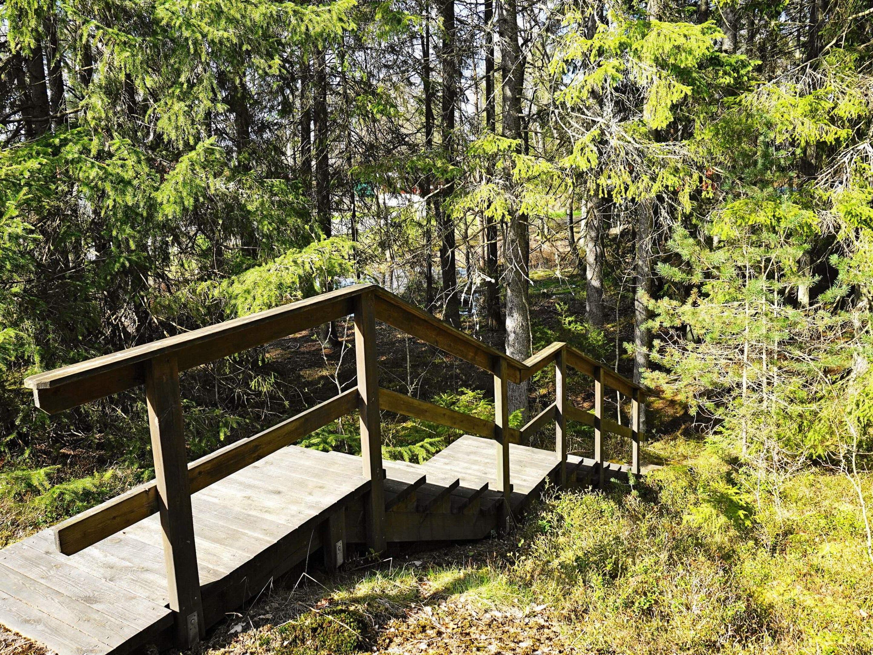 A wooden staircase leading up to a platform in a forested area.