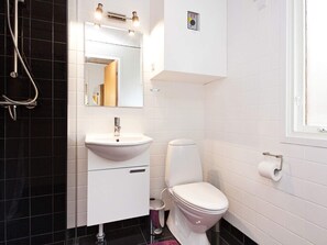 A bathroom with a white sink, a toilet, and a shower.
