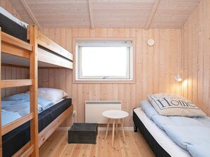 A compact room with bunk beds, a small table, a window, and a radiator. - 5 Star Holiday Home in Thisted (Thisted)