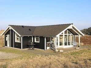 A single-story house with a dark exterior, a tiled roof, and a covered porch area. - 5 Star Holiday Home in Thisted (Thisted)