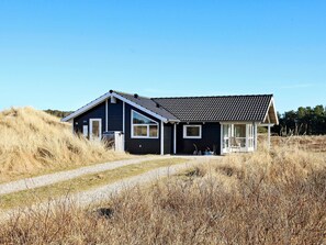 A single-story house with a dark exterior, a sloped roof, and a visible number '19' on the side. - 5 Star Holiday Home in Thisted (Thisted)