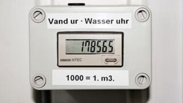 En digital vandmåler med display der viser 178565 og en omregningsfaktor på 1000 liter til 1 kubikmeter.
