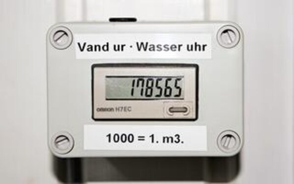 A digital water meter with a display reading 178565 and a conversion rate of 1000 liters to 1 cubic meter.