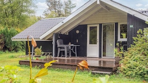 A modern house with a covered porch, a dining table, and chairs. - 6 Person Holiday Home in Oksbol (Oksbol)