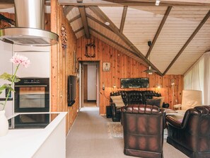A cozy cabin interior with a kitchen, living area, and a fireplace. - 6 Person Holiday Home in Oksbol (Oksbol)