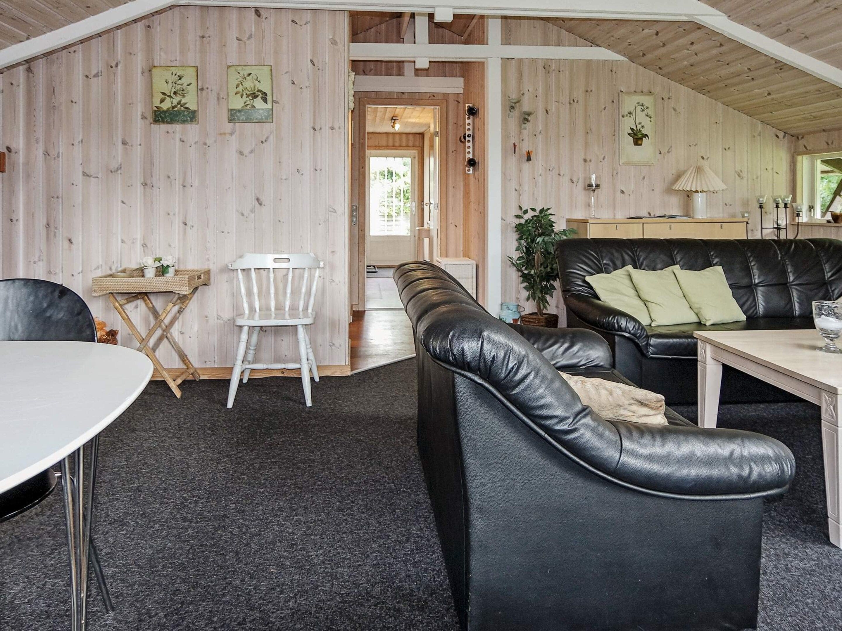 Un intérieur chaleureux avec un canapé en cuir, une table à manger et une chaise.