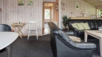 En hyggelig indretning med en lædersofa, et spisebord og en stol.