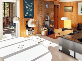 Una sala de estar acogedora con chimenea, televisor y comedor.
