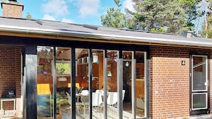 A modern house with a glass extension, a brick exterior, and a number '4' on the door. - 6 Person Holiday Home in Norre Nebel (Norre Nebel)