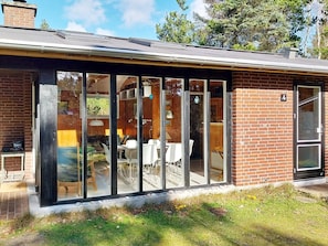 A modern house with a glass extension, brick walls, and a number 4 sign. - 6 Person Holiday Home in Norre Nebel (Norre Nebel)