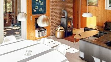 A cozy living room with a fireplace, a television, and a dining area with a table and chairs.