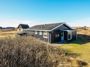 A modern black building with a sloped roof, a small porch, and a number '4' sign. - Quaint Holiday Home in Harboøre Jutland near Sea (Harboore)