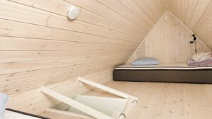 A small, triangular wooden room with a bed and a window. - 4 Person Holiday Home in Skagen (Skagen)