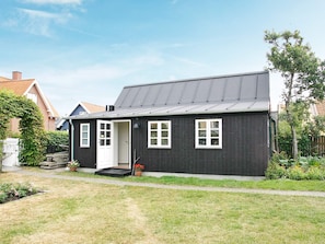 A single-story house with a dark exterior, white-framed windows, and a small porch. - 4 Person Holiday Home in Skagen (Skagen)
