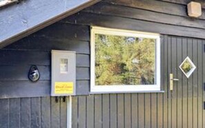 A building with a window, a door with a diamond-shaped window, and a security camera. - 4 Person Holiday Home in Oksbol (Oksbol)
