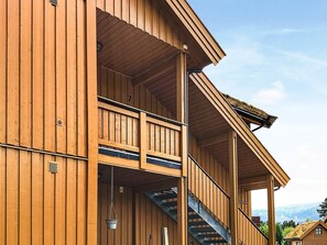 A wooden building with a balcony and a staircase. - 8 Person Holiday Home in Skulestadmo (Voss)