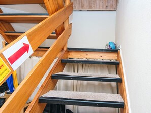 A staircase with a wooden handrail and a directional sign. - 3 Person Holiday Home in Ansager (Ansager)