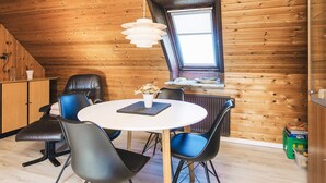 A cozy wooden room with a round table, black chairs, and a window with a view. - 3 Person Holiday Home in Ansager (Ansager)