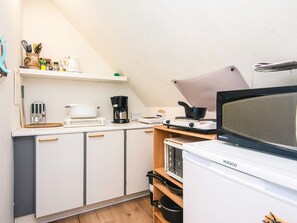A compact kitchen with white cabinets, a coffee maker, a microwave, and a stove. - 3 Person Holiday Home in Ansager (Ansager)