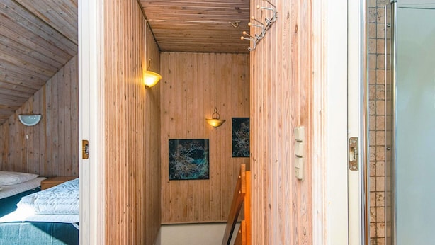 A narrow wooden hallway with a bed on the left, a door on the right, and two wall-mounted light fixtures. - 3 Person Holiday Home in Ansager (Ansager)
