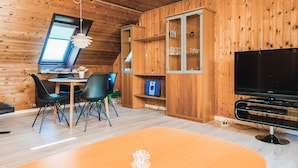 A wooden interior with a dining area, a television, and a cabinet with glass doors. - 3 Person Holiday Home in Ansager (Ansager)