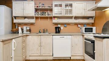 A kitchen with wooden cabinets, a dishwasher, a microwave, and a stove.
