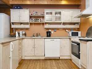 A kitchen with wooden cabinets, a dishwasher, a microwave, and a stove.