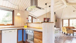 A kitchen with wooden cabinets, a dishwasher, an oven, and a window.