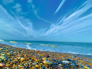 Une plage de galets avec l’océan en arrière-plan.
