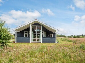 A single-story house with a gabled roof, large windows, and a front porch. - Picturesque Holiday Home in Ulfborg near Sea (Ulfborg)