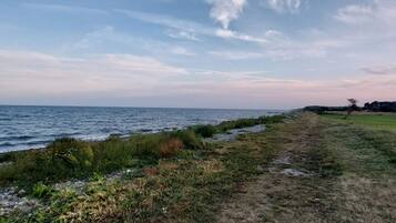 A coastal path with a view of the sea and a clear sky.