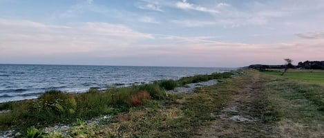A coastal path with a view of the sea and a clear sky.