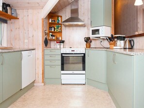 Una cocina compacta con horno integrado, microondas y lavavajillas.