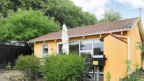 Un bâtiment jaune avec un toit en tuiles, un parasol blanc et une enseigne DanCenter.